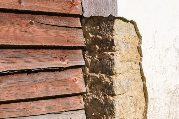 Closeup of damaged stucco siding | Precision Contracting Services